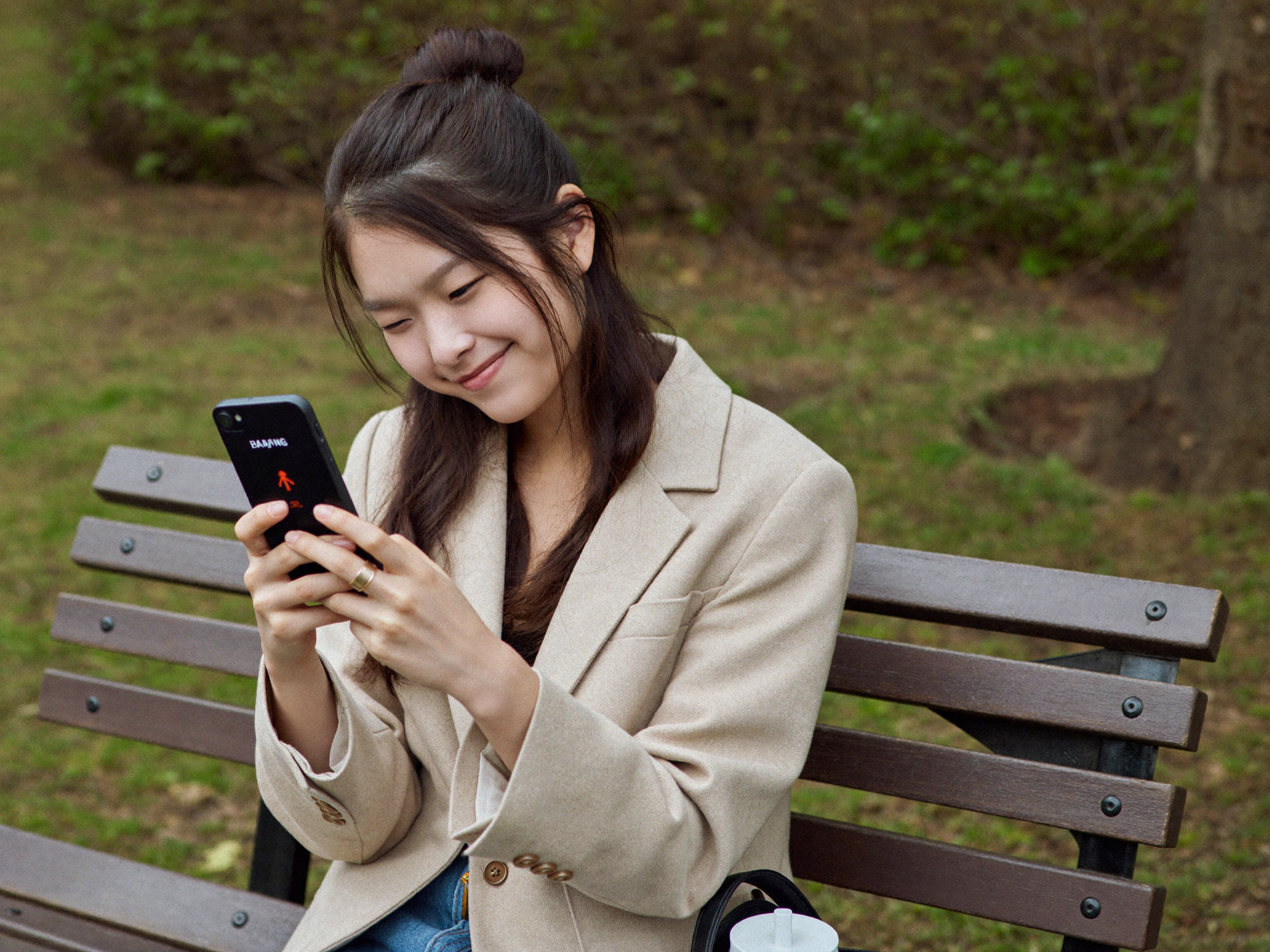公園でスマホを見てため息をつく女性
